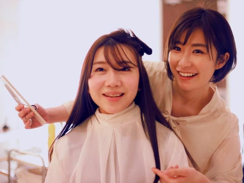 Smiling hairstylist showing client her haircut progress. Great service once, poor next time? It breaks client trust faster than you think.