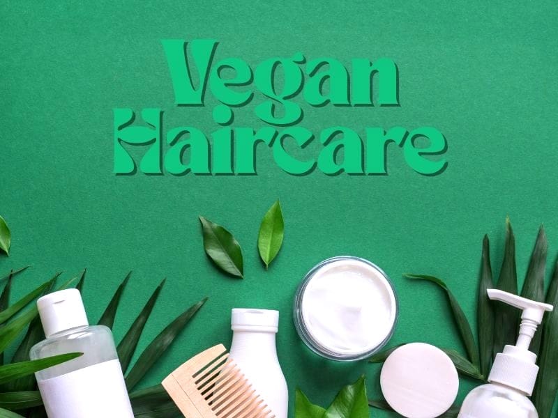 Vegan haircare products on green background with leaves and natural beauty theme.