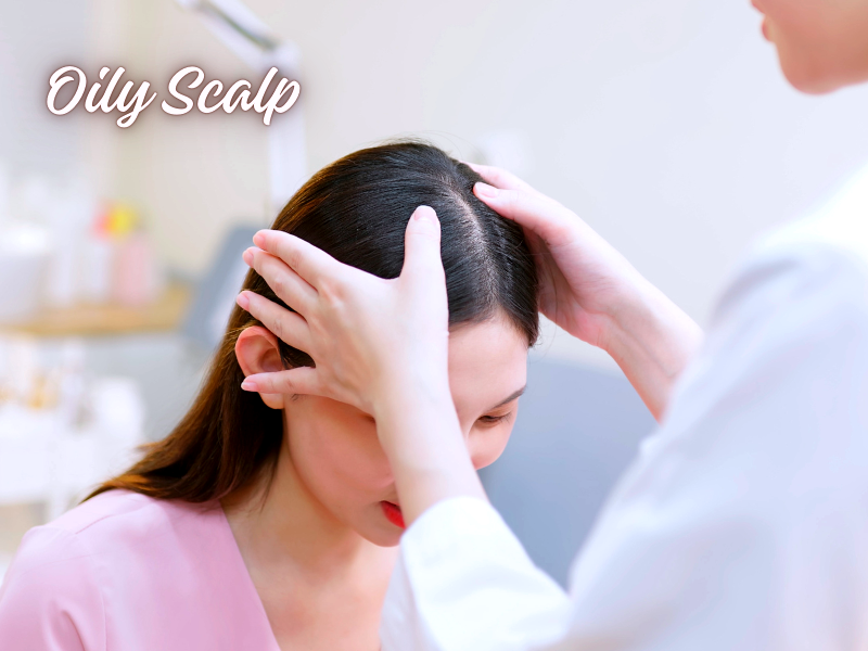 Stylist examines woman’s oily scalp under soft lighting, text in corner reads “Oily Scalp”.