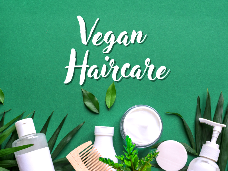 Vegan haircare products with natural leaves on green background promoting plant-based beauty.