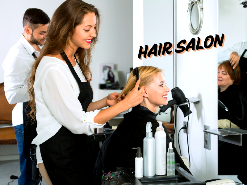 Hair stylist brushing a smiling woman’s hair at a salon, promoting healthy and damage-free care.