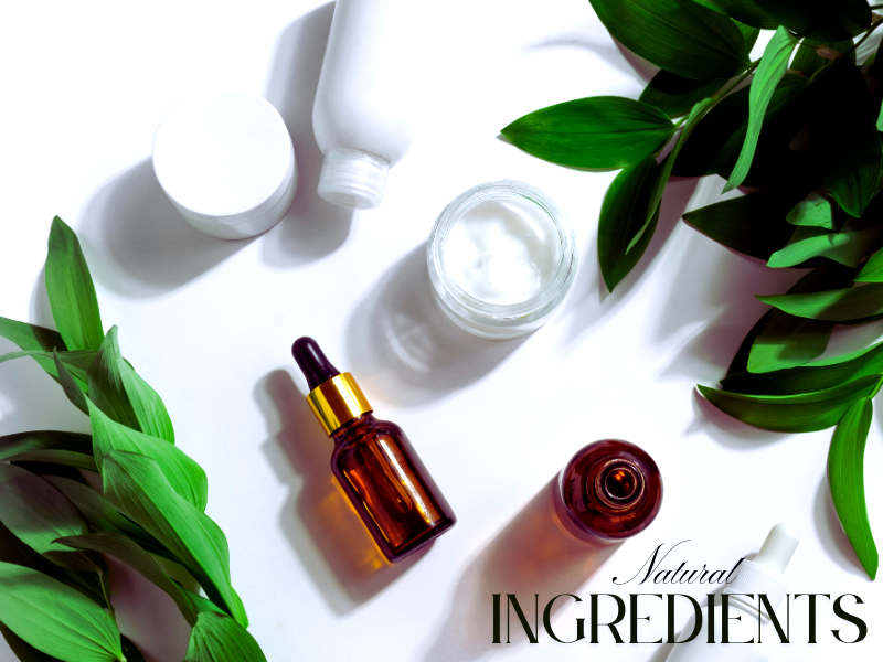 Natural haircare and skincare ingredients with fresh green leaves and product containers on a white background.