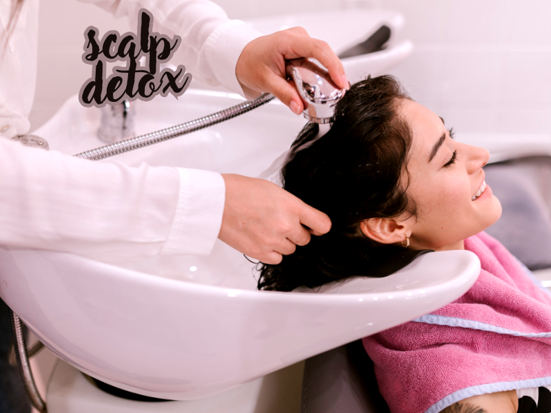 Smiling woman enjoys scalp detox at salon sink, promoting clean haircare and client satisfaction.