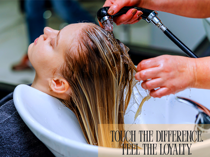 Hair being rinsed at a salon basin – elevate client loyalty with a touchably smooth, salon-quality experience.