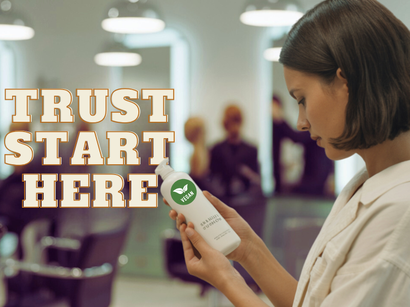 Woman examining vegan shampoo bottle in salon with text “Trust Starts Here” promoting clean beauty.